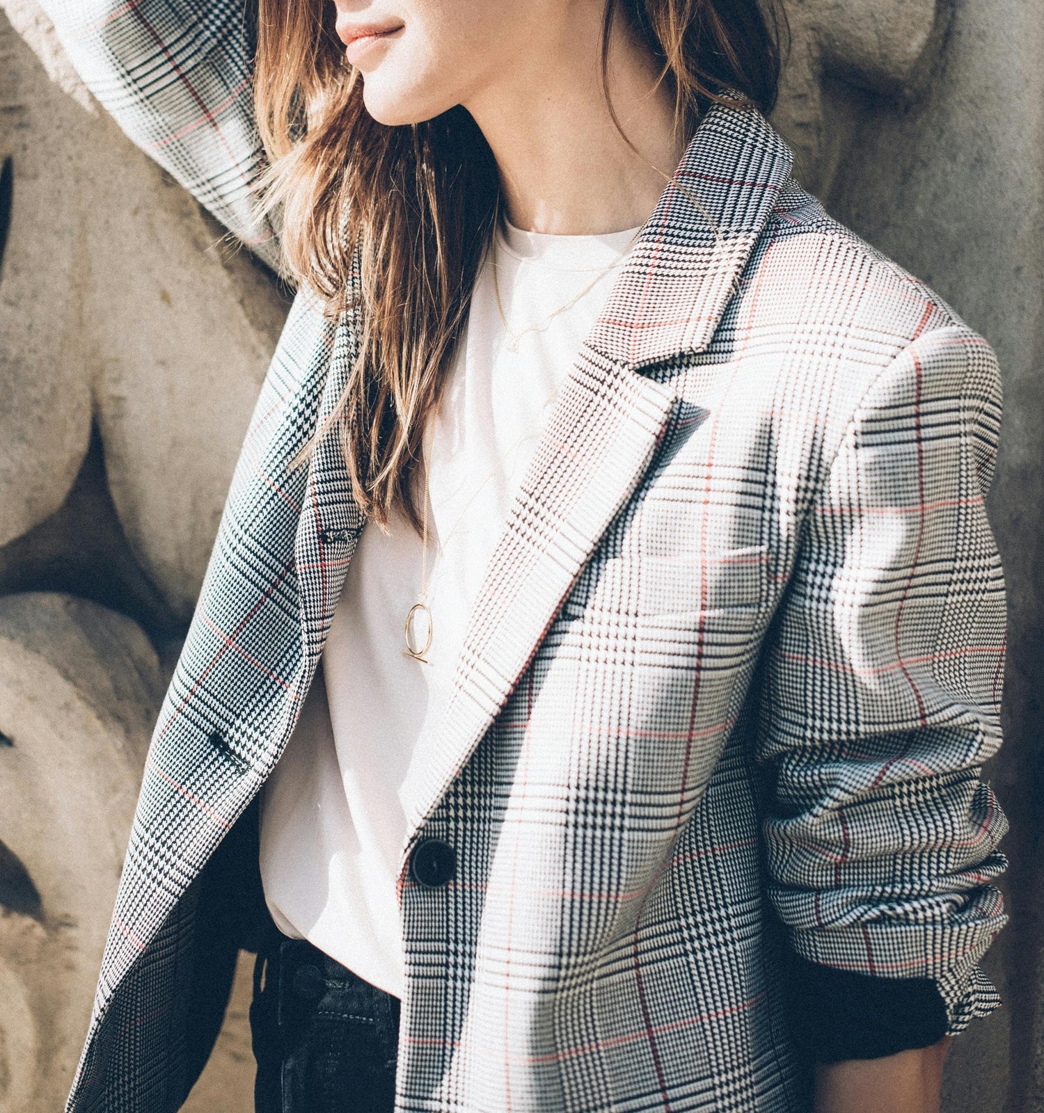 Chic woman dressed in a check blazer, white t-shirt, and jean curated by Styled After.