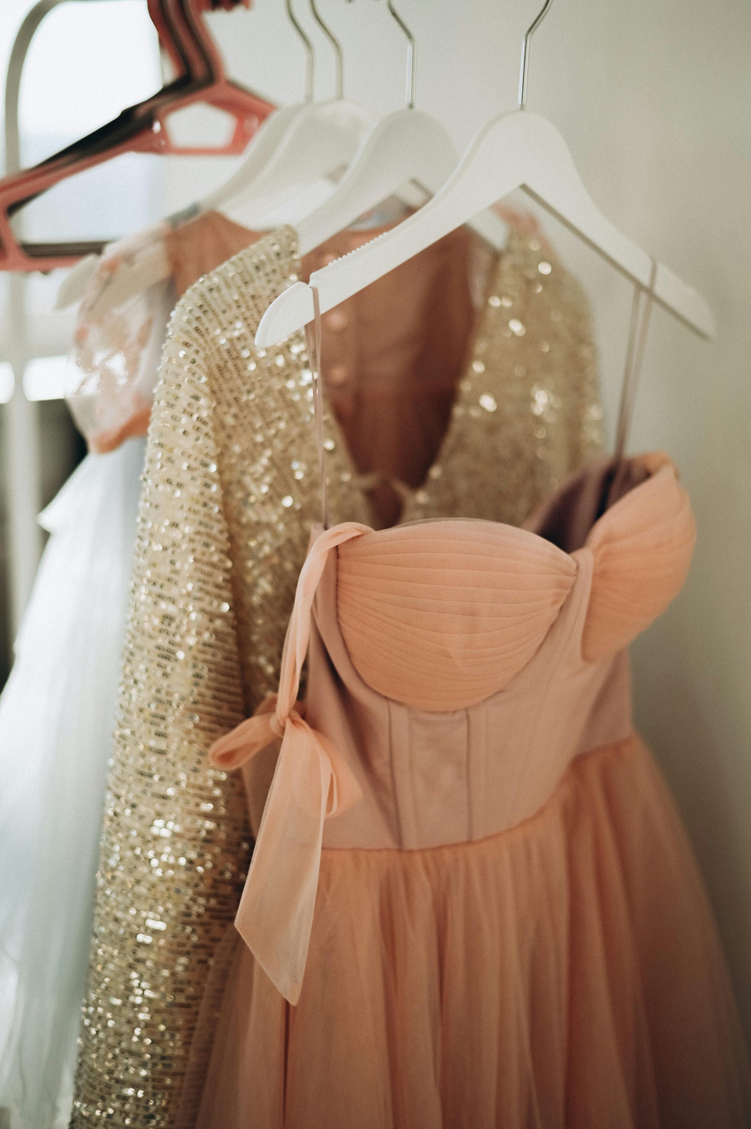 Gold sequin dress and pink dress in a closet curated by Styled After.