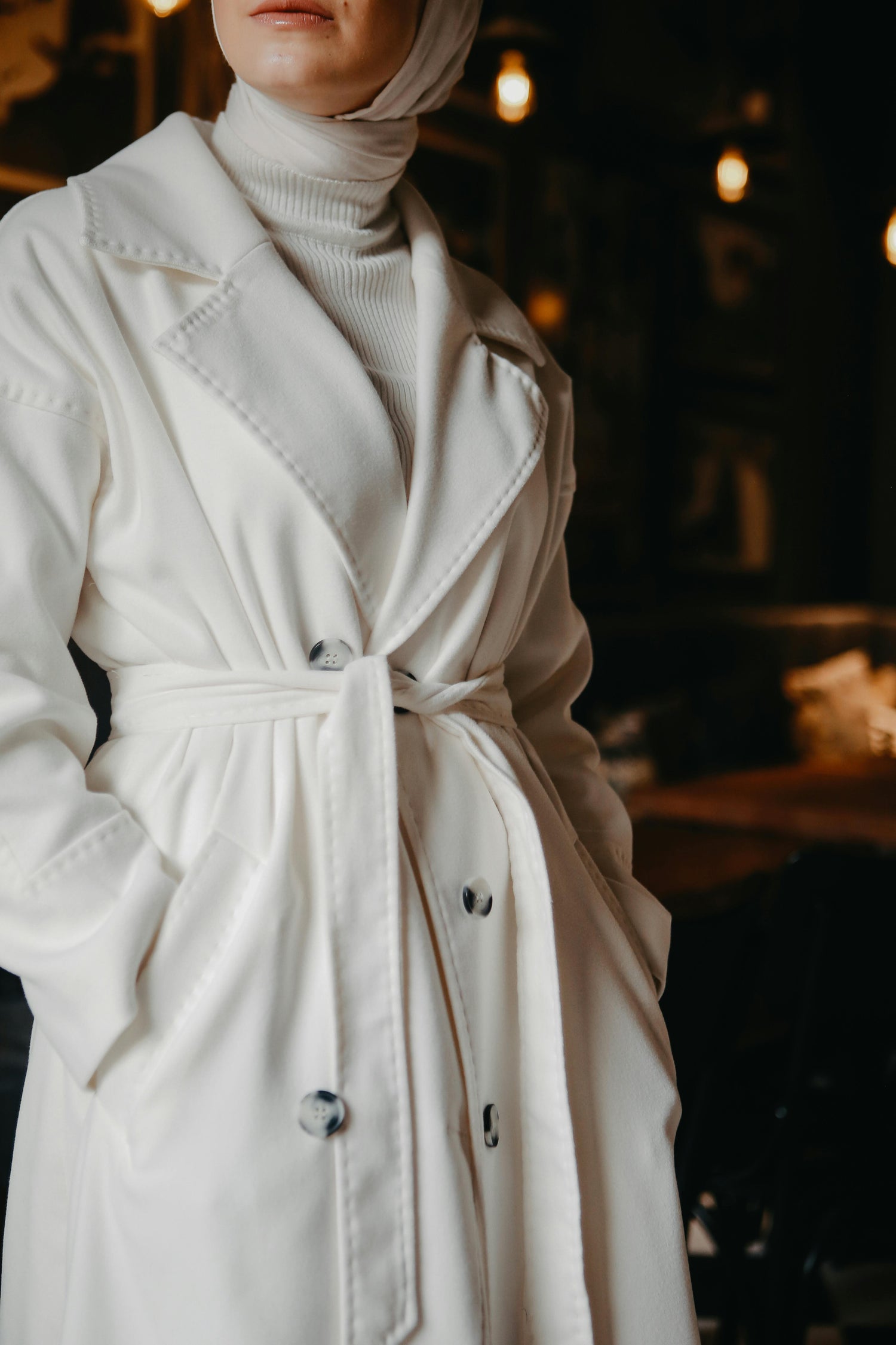 Woman in white trench coat and turtleneck, classic elegance from Styled After.
