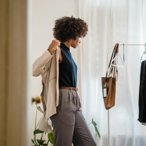 Professional stylish woman trying on clothes in elegant workwear curated by Styled After.