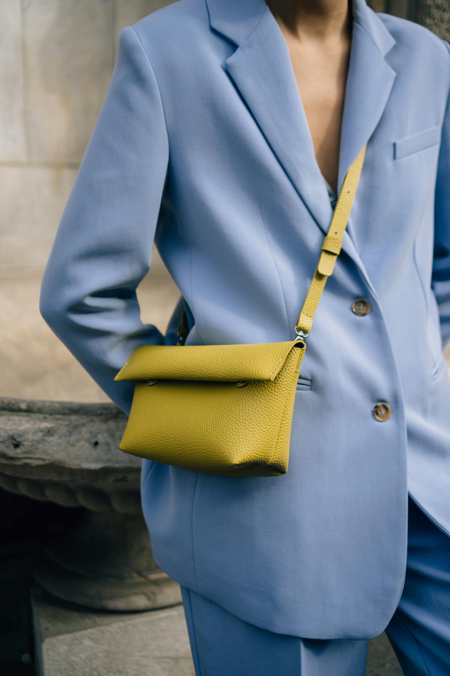 Sky blue suit with a chartreuse crossbody bag, inspired by Miranda Hobbes in And Just Like That, curated by Styled After.
